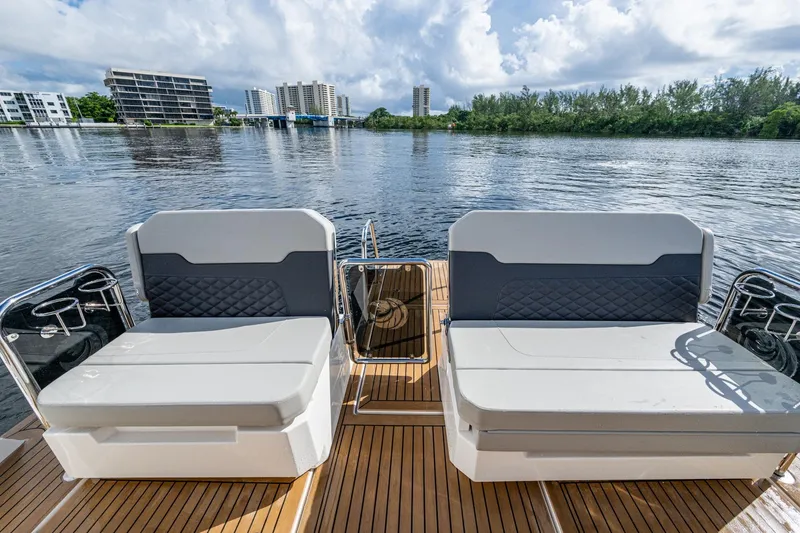 Slide: The Image of Aquila 32 Power Cat 2023 with stylish seating on a serene waterfront. - 32