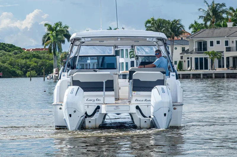 Slide: The Image of 2023 Aquila 32 Power Cat cruising on a scenic waterway with palm trees. - 47