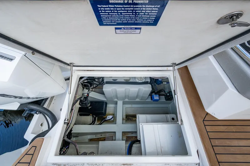 Slide: The Image of Engine compartment of 2023 Aquila 32 Power Cat with open hatch, showcasing internal components. - 6