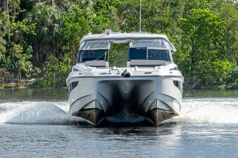 Slide: The Image of 2023 Aquila 32 Power Cat cruising on a scenic river, surrounded by lush greenery. - 63