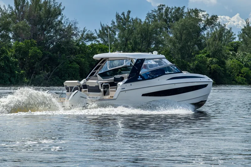 Slide: The Image of 2023 Aquila 32 Power Cat cruising on a scenic waterway with lush greenery. - 69