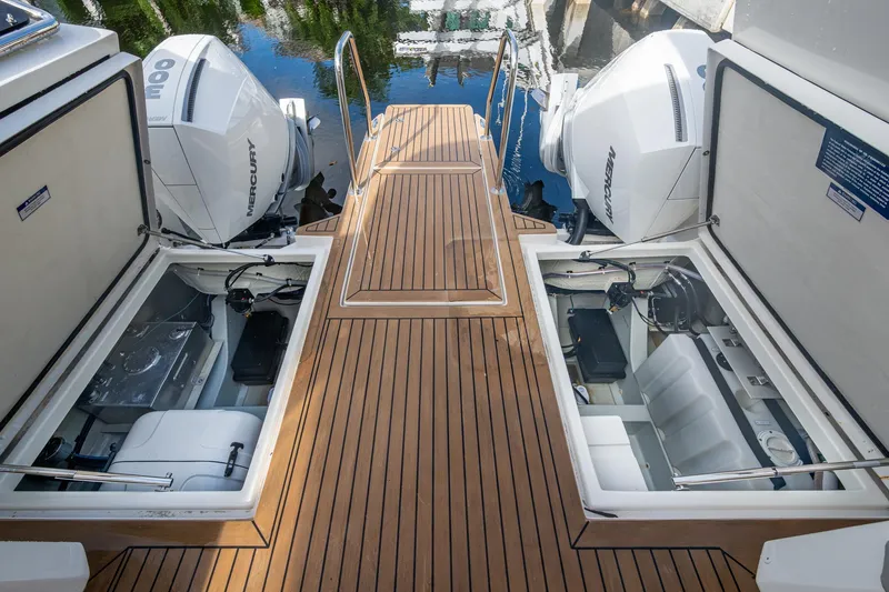 Slide: The Image of 2023 Aquila 32 Power Cat with open engine compartments and twin Mercury outboards. - 7