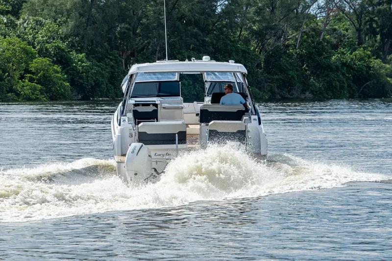 Slide: The Image of 2023 Aquila 32 Power Cat cruising on a scenic river with lush greenery. - 70
