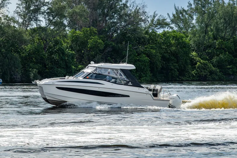 Slide: The Image of 2023 Aquila 32 Power Cat cruising on a scenic river with lush greenery. - 71