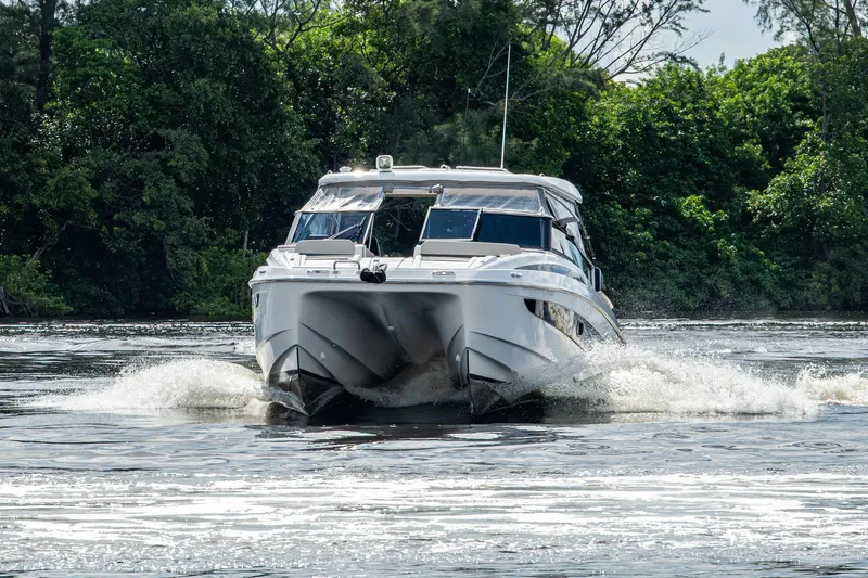 Slide: The Image of 2023 Aquila 32 Power Cat cruising on a scenic river with lush greenery. - 73