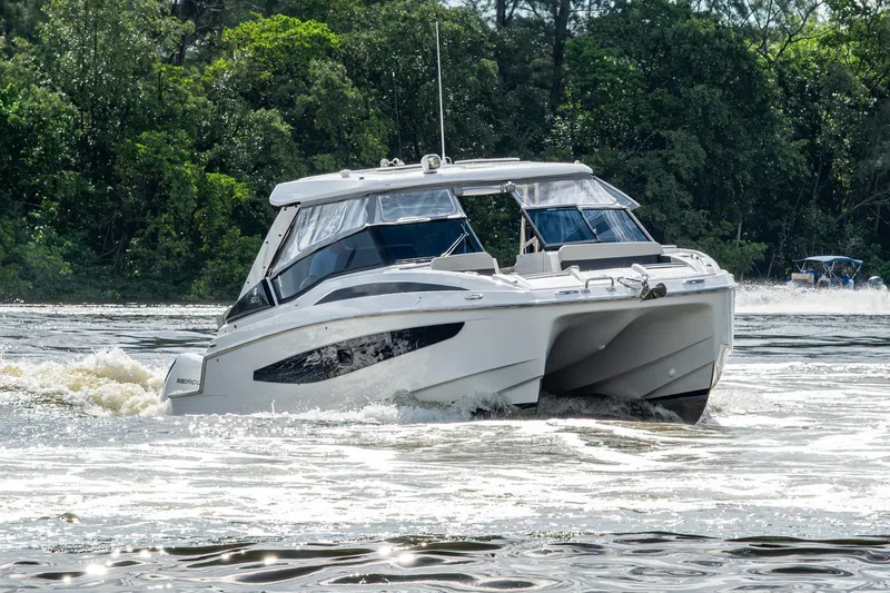 Slide: The Image of 2023 Aquila 32 Power Cat cruising on a scenic river with lush greenery. - 77