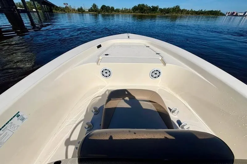 Slide: The Image of 2023 Scout 177 Sport boat interior on calm water, featuring seating and speakers. - 11