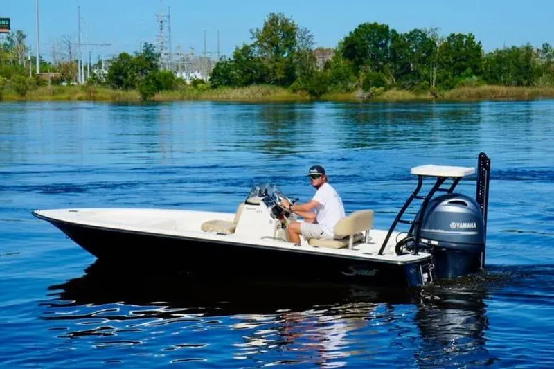 Slide: The Image of 2023 Scout 177 Sport boat cruising on a calm lake with Yamaha engine. - 2