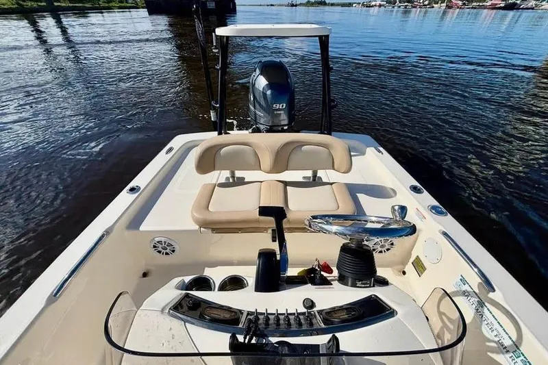 Slide: The Image of 2023 Scout 177 Sport boat interior with steering wheel and outboard motor on water. - 6
