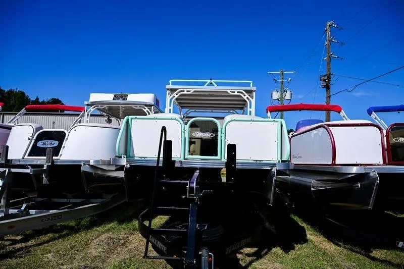 Slide: The Image of 2022 Aloha Pontoon 260 Tropical Series Sundeck boats displayed outdoors under clear blue sky. - 3