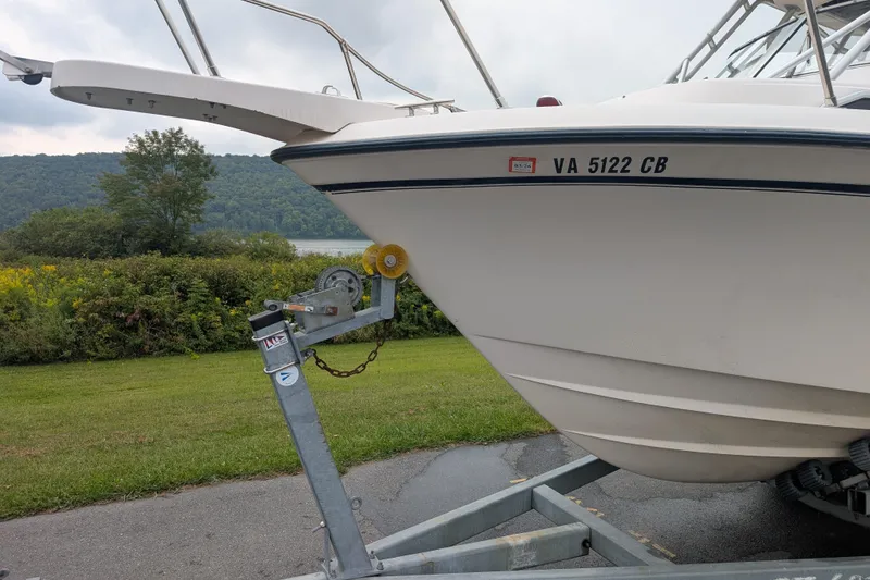 Slide: The Image of 2002 Grady-White Voyager 248 boat on trailer, parked near scenic lake and greenery. - 11