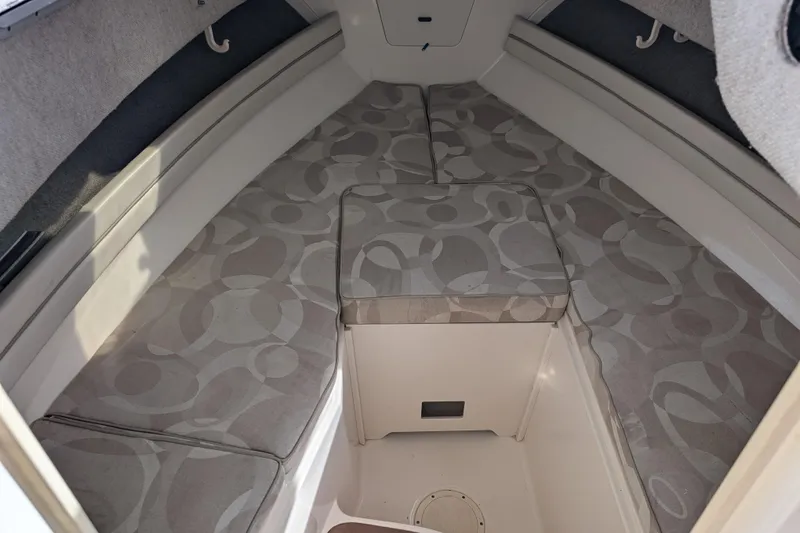 Slide: The Image of 2002 Grady-White Voyager 248 cabin interior with patterned cushions and storage space. - 13