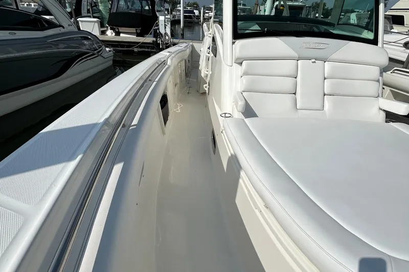 Slide: The Image of 2016 Boston Whaler 370 Outrage boat with white seating, docked among other boats. - 12