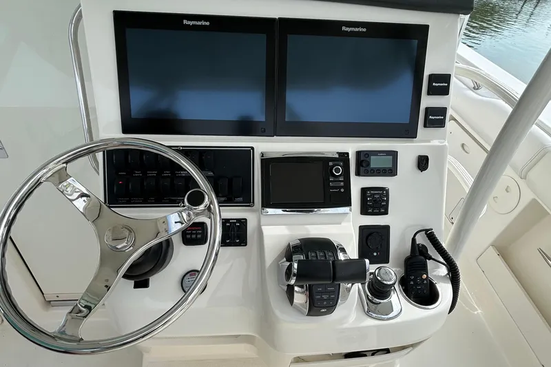 Slide: The Image of 2016 Boston Whaler 370 Outrage boat interior with seating and storage, docked at marina. - 13
