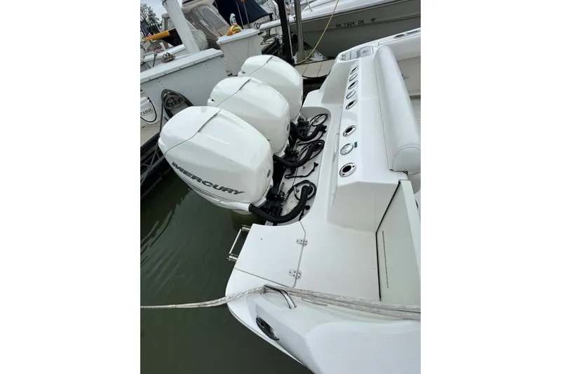 Slide: The Image of 2016 Boston Whaler 370 Outrage boat on water near marina, overcast sky. - 5