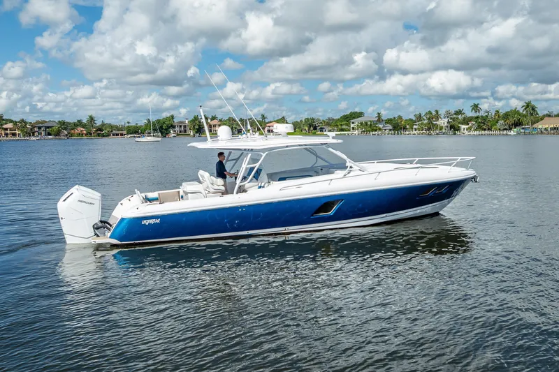 Slide: The Image of 2018 Intrepid 407 boat cruising on a calm lake under a partly cloudy sky. - 1