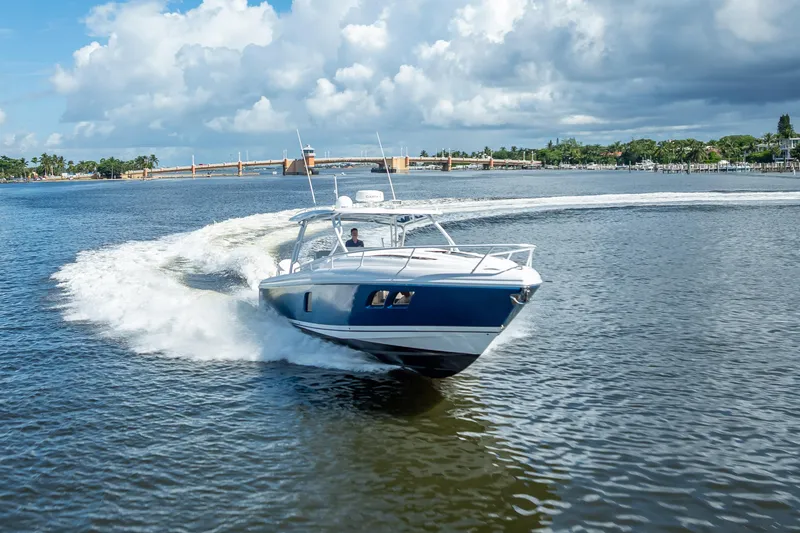 Slide: The Image of 2018 Intrepid 407 boat cruising on a sunny day with scenic waterfront backdrop. - 11
