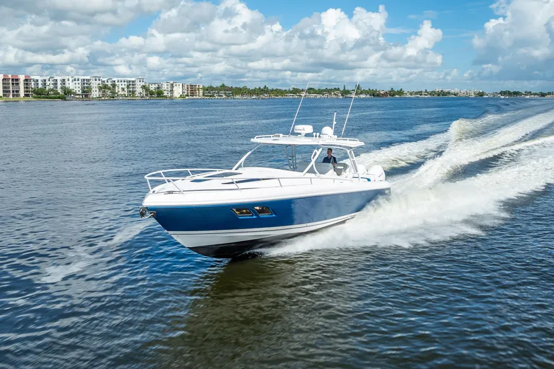 Slide: The Image of 2018 Intrepid 407 boat cruising on a sunny day with scenic waterfront views. - 12