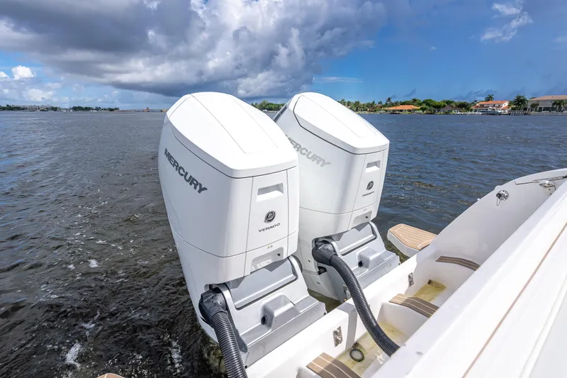 Slide: The Image of Twin Mercury Verado engines on a 2018 Intrepid 407 boat, cruising on a scenic waterway. - 15