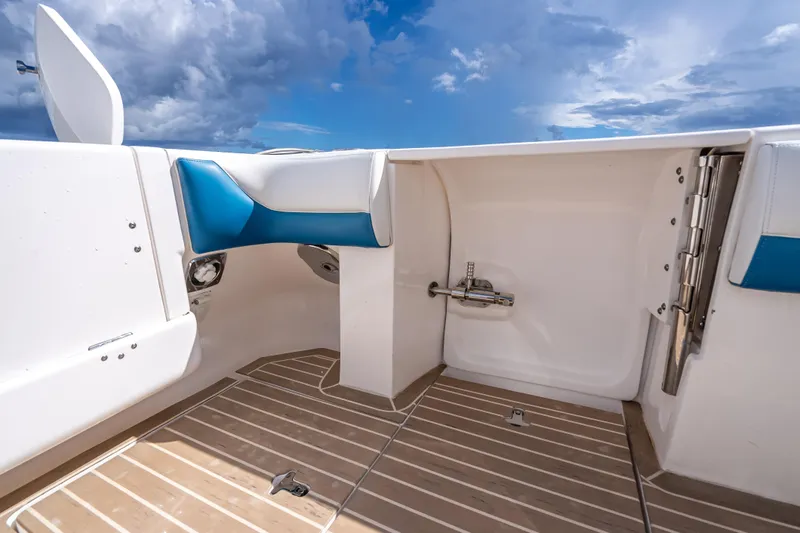 Slide: The Image of 2018 Intrepid 407 boat interior with blue and white seating, wooden flooring, and open sky view. - 18