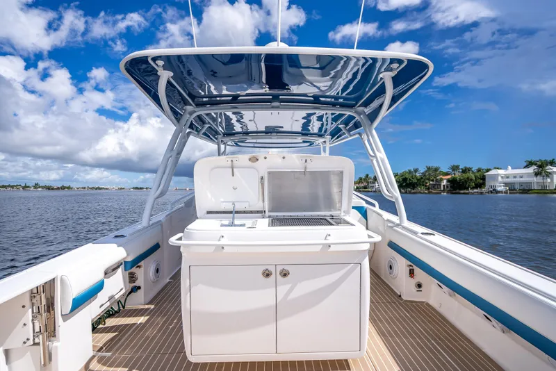 Slide: The Image of 2018 Intrepid 407 boat with sleek design, spacious deck, and modern amenities on a sunny day. - 21