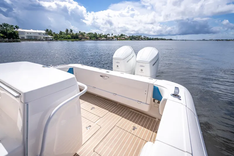 Slide: The Image of 2018 Intrepid 407 boat with dual Mercury engines on a serene waterway. - 25