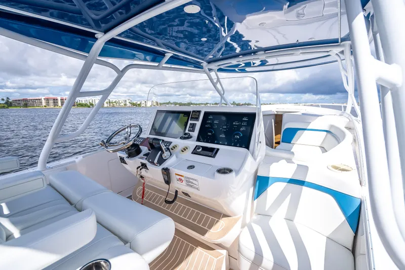 Slide: The Image of 2018 Intrepid 407 boat interior with modern dashboard and seating on a sunny day. - 28