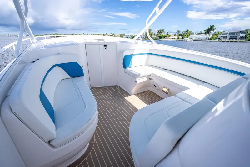 Slide: The Image of 2018 Intrepid 407 boat interior with white and blue seating, overlooking a scenic waterfront. - 35