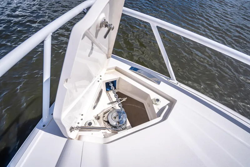 Slide: The Image of 2018 Intrepid 407 boat anchor compartment with open hatch, on calm water. - 38