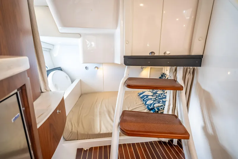 Slide: The Image of Interior cabin of 2018 Intrepid 407 boat with wooden steps and cozy sleeping area. - 42