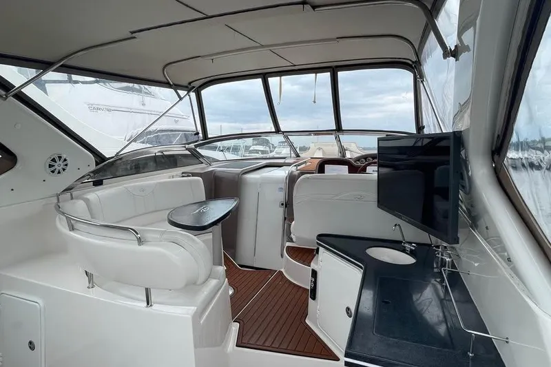 Slide: The Image of 2003 Regal Commodore 3560 IB yacht interior with seating, TV, and kitchenette. - 10
