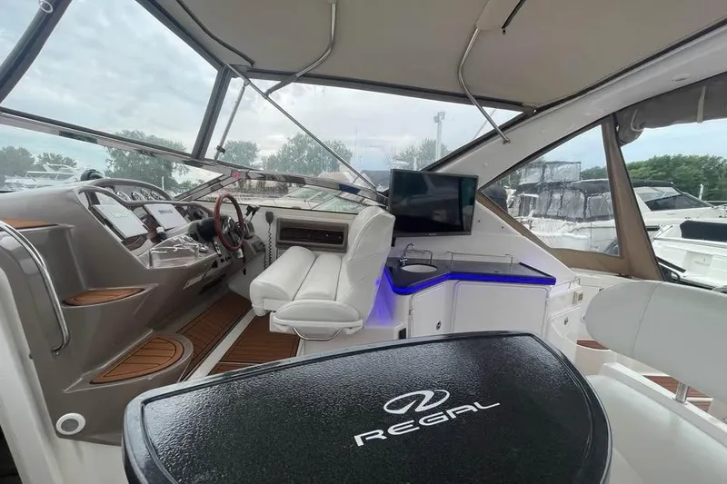 Slide: The Image of 2003 Regal Commodore 3560 IB yacht interior with modern helm, seating, and entertainment area. - 14