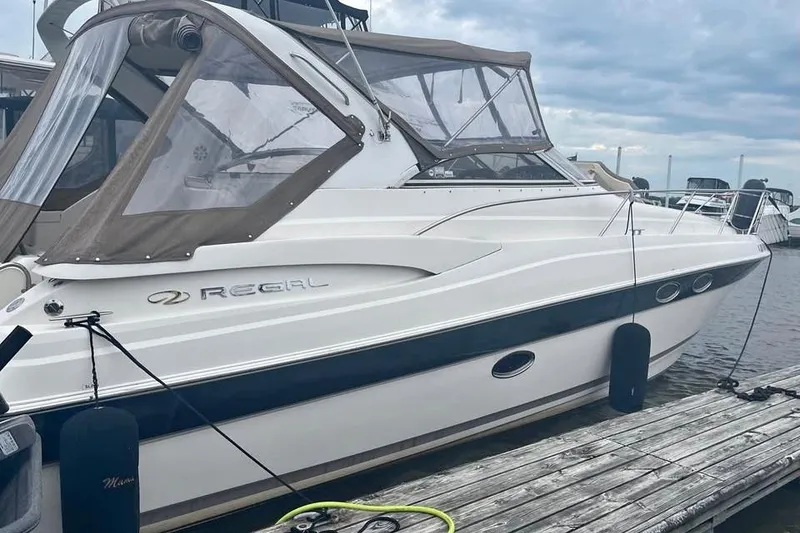 Slide: The Image of 2003 Regal Commodore 3560 IB yacht docked at marina under cloudy sky. - 2