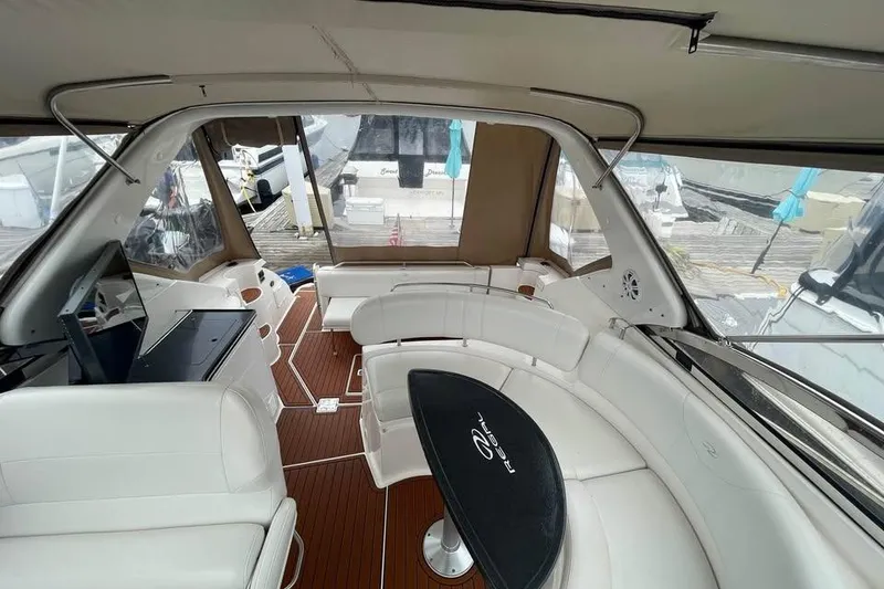 Slide: The Image of Interior of 2003 Regal Commodore 3560 IB yacht with white seating and wood flooring. - 9