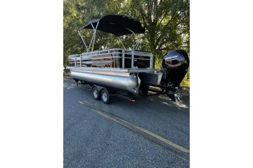 Slide: The Image of 2026 Sun Tracker SportFish 22 DLX pontoon boat with canopy and Mercury outboard motor. - 2