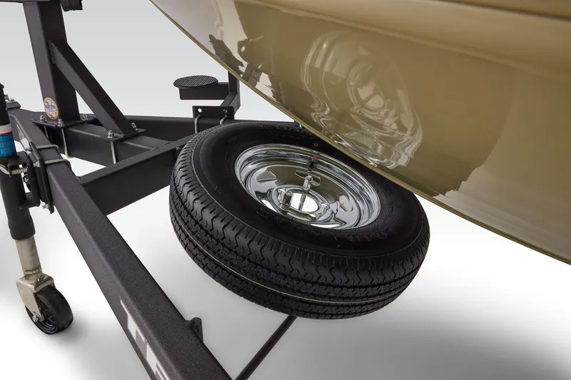 Slide: The Image of 2026 Tracker Targa V-19 Combo trailer with spare tire and boat hull reflection. - 62