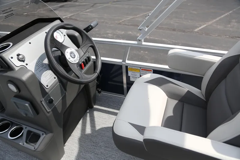 Slide: The Image of 2026 Sun Tracker Bass Buggy 16 XL Select boat interior with steering wheel and seat. - 3