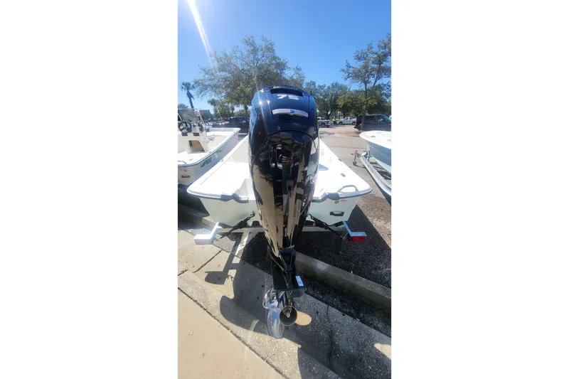 Slide: The Image of 2026 Mako Pro Skiff 17 CC boat with outboard motor in a sunny outdoor setting. - 2