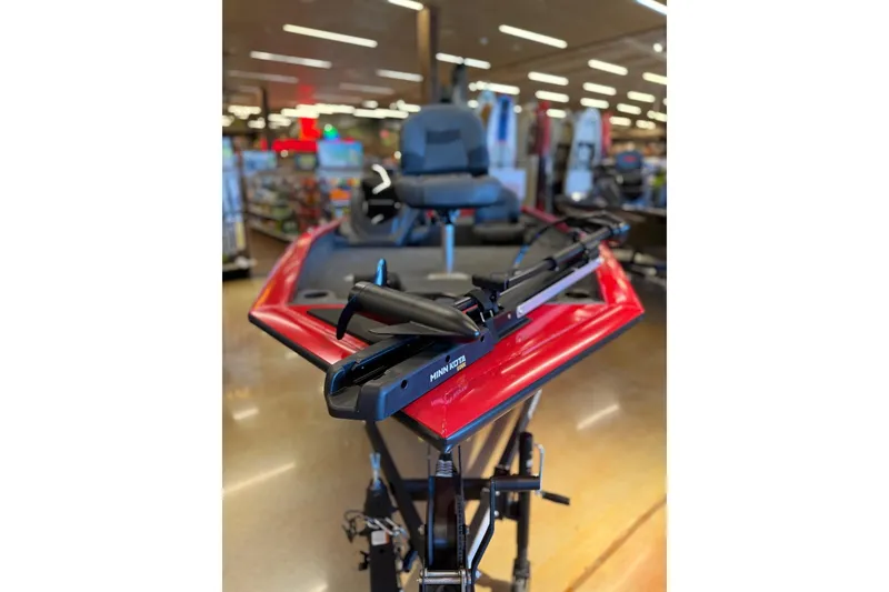 Slide: The Image of 2026 Tracker Pro Team 175 Crappie Edition boat displayed indoors, featuring a red hull and trolling motor. - 7