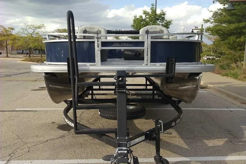 Slide: The Image of 2026 Sun Tracker Bass Buggy 16 XL Select pontoon boat on trailer in parking lot. - 84