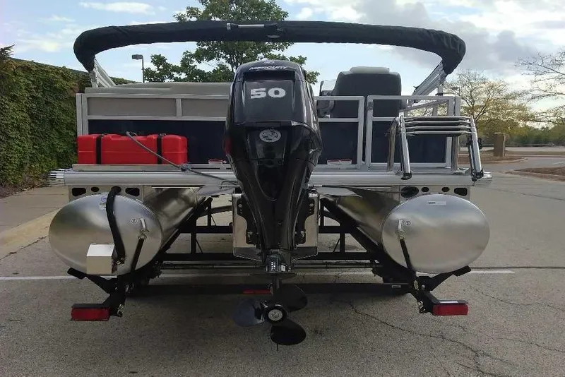 Slide: The Image of 2026 Sun Tracker Bass Buggy 16 XL Select pontoon boat with outboard motor, rear view. - 16