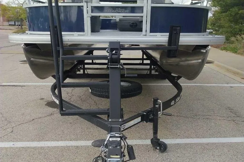 Slide: The Image of 2026 Sun Tracker Bass Buggy 16 XL Select pontoon boat on trailer in parking lot. - 12