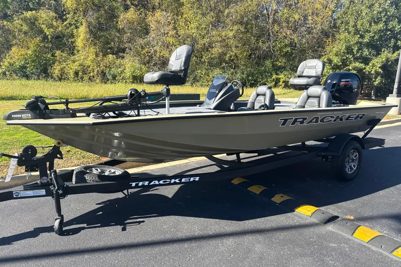 The Image of 2026 Tracker Pro Team 195 boat on trailer, parked outdoors, surrounded by trees. - 0