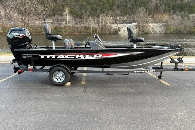 Slide: The Image of 2026 Tracker Pro Team 175 Crappie Edition boat with Mercury engine, parked near a bridge. - 23