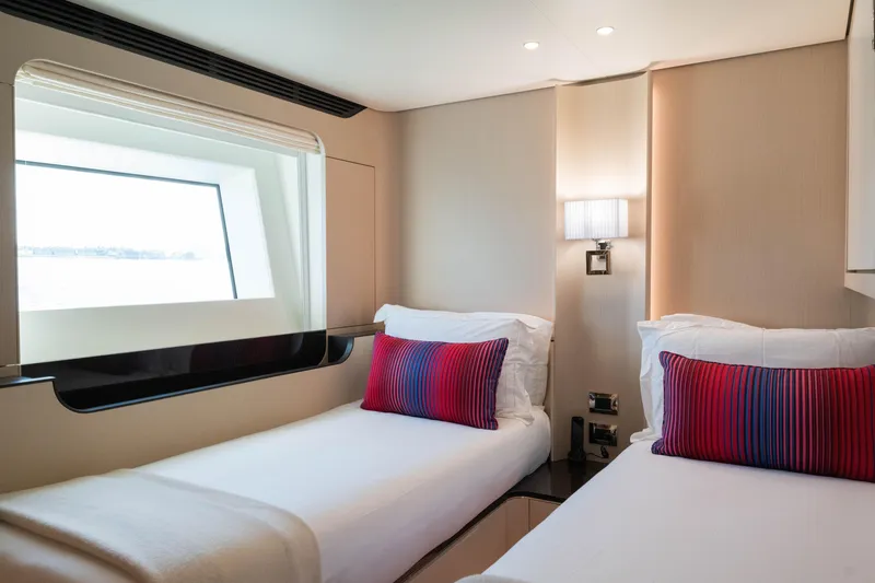 Slide: The Image of Luxurious 2023 Azimut yacht cabin with twin beds, modern decor, and ocean view window. - 50