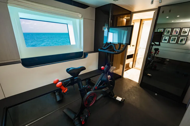 Slide: The Image of Luxury yacht interior with exercise bike, ocean view window, and modern decor, Azimut 2023. - 62