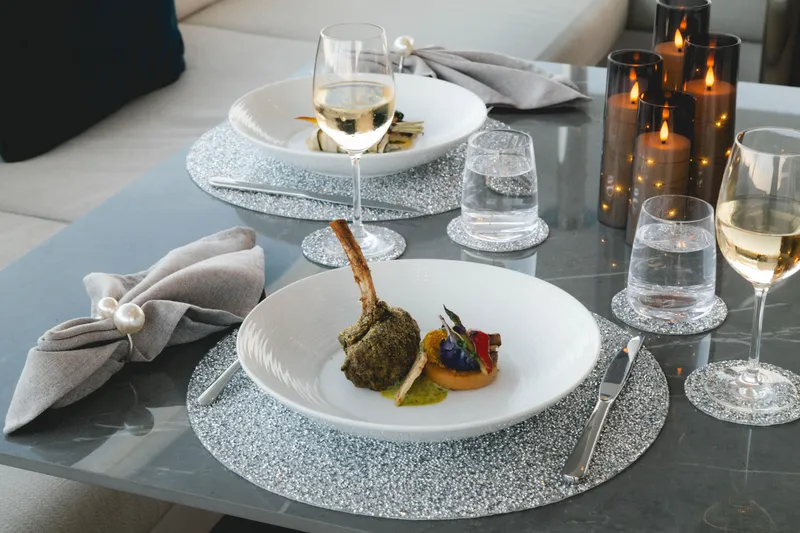 Slide: The Image of Elegant dining setup on Azimut yacht, featuring gourmet dish, wine, and candles, 2023. - 67