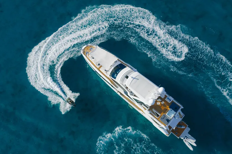 Slide: The Image of Aerial view of 2023 Azimut yacht with jet ski creating waves in blue ocean. - 9