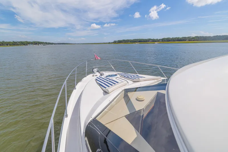 Slide: The Image of 2006 Meridian 341 Sedan yacht cruising on a serene lake under a clear blue sky. - 34