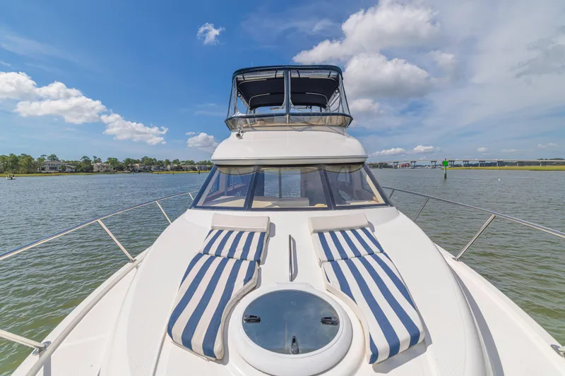 Slide: The Image of 2006 Meridian 341 Sedan yacht on water, featuring striped deck cushions under a blue sky. - 37
